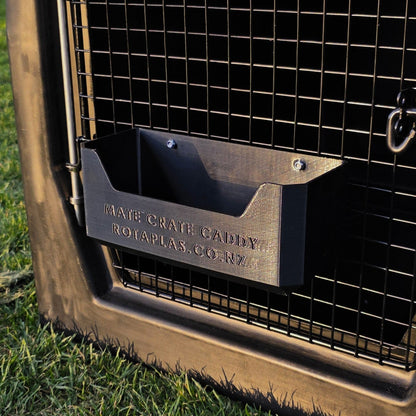 A black dog crate caddy hooked onto the door of a black Rotaplas Mate Crate made to store dog accessories